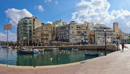Boats moored in Spinola Bay with the Love Monument on the right side. - San Giljan, (St. Julian’s), Malta.