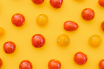 Naklejka na ściany i meble Fresh cherry tomatoes on yellow background