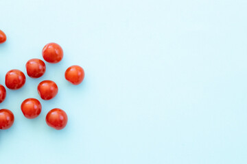 Fresh red cherry tomatoes on blue background