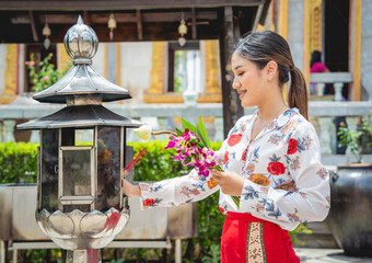 Beautiful Asian girl at big Buddhist temple dressed in traditional costume