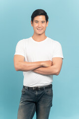 Nice asian guy in white t-shirt and jeans isolated on blue background