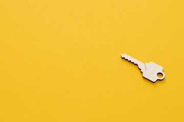Life coaching concept - wooden key standing on a yellow background