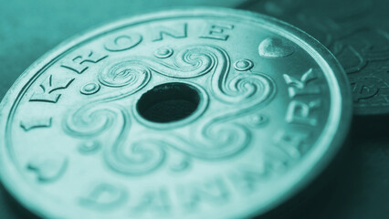 1 Danish krone coin close-up. National currency and money of Denmark. Turquoise tinted wallpaper for news about economy or finance. Bank and loan. Savings and interest. Macro