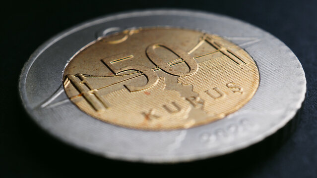 Translation: 50 kurus. Turkish coin of 50 kuruş lies on a dark surface closeup. National currency of Turkey. Illustration for news about economy or banking. Bosphorus Bridge. Macro