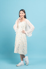 Beautiful young asian woman in white dress with flower pattern isolated on blue background