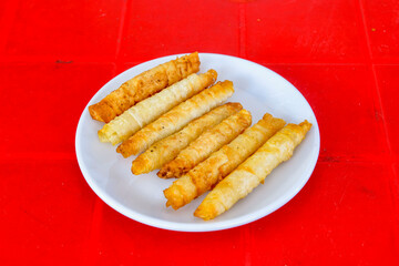 Turkish style meat stuffed filo dough borek served kol boregi. Cheese and minced pie are sliced on a marble background. Turkish name: Kol Boregi, kiymali, peynirli su boregi.