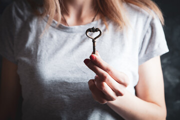 young woman holding old keys in hand
