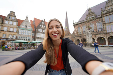 Pretty woman takes selfie photo in Bremen Market Square with Roland statue, Bremen, Germany - obrazy, fototapety, plakaty
