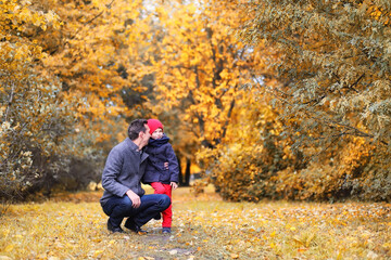 Naklejka na ściany i meble Family in autumn park in the afternoon