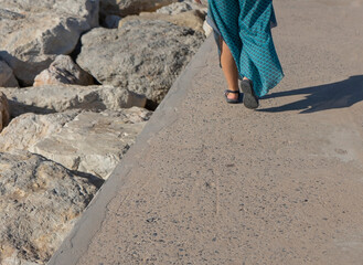 Woman walking with sandals on a jetty