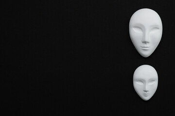 Two white gypsum mask of human with closed eyes on black background - obrazy, fototapety, plakaty