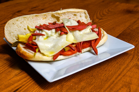 Close-up shot of Izmir's famous Turkish Traditional Kumru Sandwich, &Ccedil;eşme Kumru, Karisik sandvic,  ingredients ready to eat salami, soudjouk, tomato, cheddar cheese and fried cheese. Yengen sandvic.