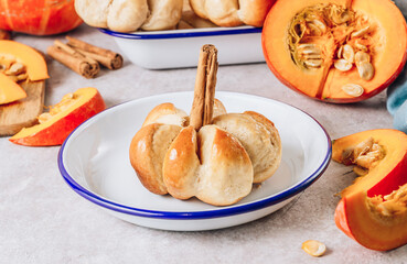 Pumpkin buns bread with cinnamon on enamel plate. Autumn, Halloween food concept.