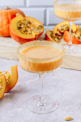 Autumn, Thanksgiving cocktails. Pumpkin margarita or Martini with cinnamon on stone table.