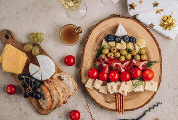 Christmas snack tree on rustic wooden board over stone background. Cheese plate. Christmas food concept.