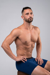 Fototapeta premium Shirtless, muscular male posing for the camera and flexing
