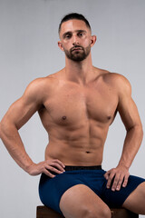 Fototapeta na wymiar Shirtless, muscular male posing for the camera and flexing