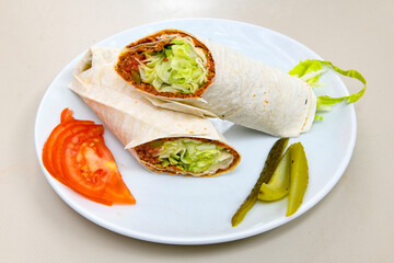 Cig kofte (raw meatball) with lettuce, tomato, pickle and lemon, hot Chee kofta. Turkish local raw food concept.Table scene of assorted take out or delivery foods. Doritoslu cig kofte durum.