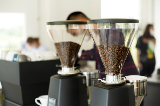 Coffee beans in machine for barista making espresso coffee menu.Aromatic coffee beans in a modern roasting machine with a blurred image of professional coffee roaste.