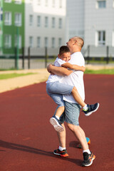 Boy jumped on Dad, hugged, laughing, Father's Day Concept