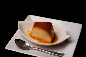 piece of pudding on plate with spoon on the side