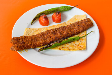 Grilled Turkish Adana, Urfa  Kebab with grilled vegetables, onion and rice on plate. Adana durum .