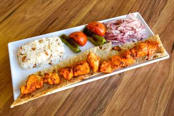 Chicken wings barbeque in a dish with BBQ sauce . Izgara tavuk sis kanat.