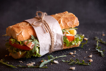 Baguette sandwich with cheese, ham, tomatoes and vegetables