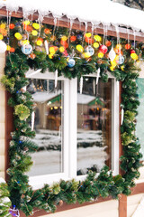 Fototapeta na wymiar Christmas window decor. Street, winter, icicles. Christmas tree decoration on the street, decorated with garlands and toys