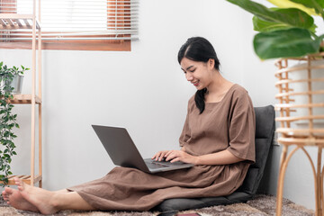 Beautiful woman is using laptop to chatting and talking with friends on video call while sitting