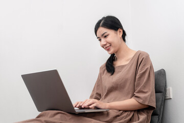 Beautiful woman is using laptop to chatting and talking with friends on video call while sitting