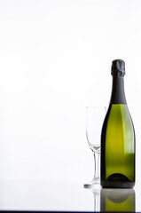 Bottle of champagne and a glass on a white background