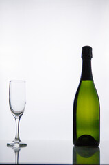 Bottle of champagne and a glass on a white background