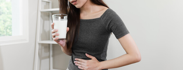 lactose intolerance concept. Woman pushing glass of milk deny to drink.