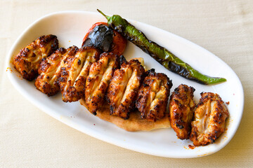 Chicken wings barbeque in a dish with BBQ sauce . Izgara tavuk sis kanat.