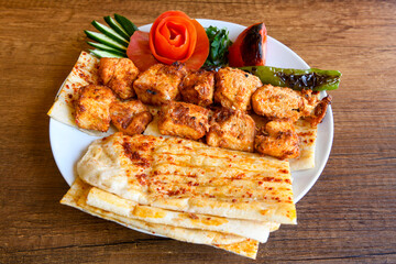 Chicken wings barbeque in a dish with BBQ sauce . Izgara tavuk sis kanat.