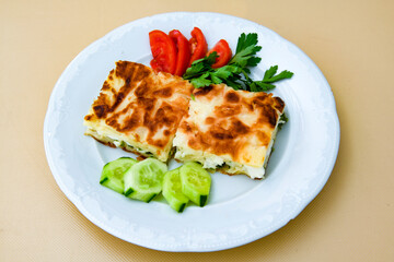 Turkish style meat stuffed filo dough borek served kol boregi. Cheese and minced pie are sliced on a marble background. Turkish name: Kol Boregi, kiymali, peynirli su boregi.