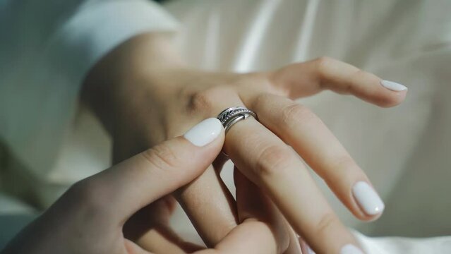The girl touches the ring on her hand with her fingertips. Close-up shooting