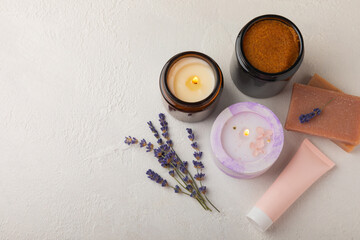 Lavender spa. Lavender flowers, handmade soap, body cream, scrub and aroma candles. Natural herbal cosmetics with lavender flowers on white texture background.