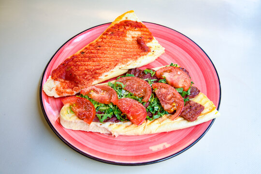 Close-up shot of Izmir's famous Turkish Traditional Kumru Sandwich, Ceşme Kumru, patso ingredients ready to eat salami, soudjouk, tomato, cheddar cheese and fried cheese. Yengen sandvic.