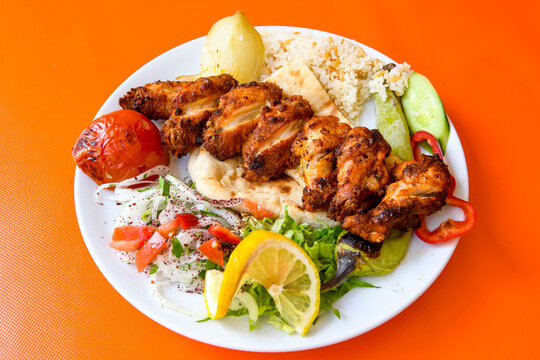 Chicken wings barbeque in a dish with BBQ sauce . Izgara tavuk sis kanat.