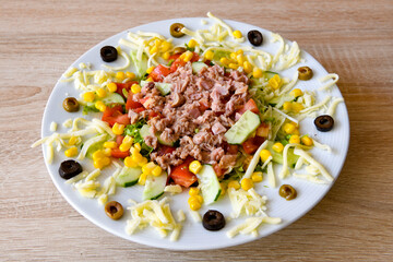 Green salad with arugula, lamb and tomatoes. Healthy vegan dish. Top view at table. Turkish Coban (choban) salata or Shepherds salad, Akdeniz salad in white bowl.