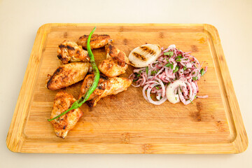 Chicken wings barbeque in a dish with BBQ sauce . Izgara tavuk sis kanat.