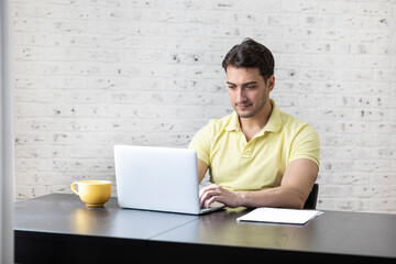 Serious businessman sitting at the table at home and working. Distant work concept	