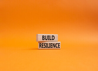 Build resilience symbol. Wooden blocks with words Build resilience. Beautiful orange background. Business and Build resilience concept. Copy space.