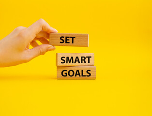 Set smart goals symbol. Concept words Set smart goals on wooden blocks. Beautiful yellow background. Businessman hand. Business and Set smart goals concept. Copy space.