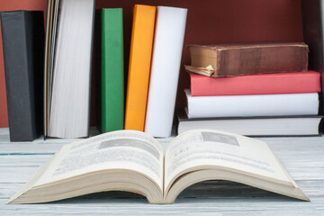 Open book, hardback colorful books on wooden table. Back to school. Copy space for text. Education business concept.