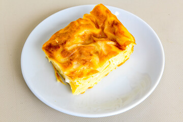Turkish style meat stuffed filo dough borek served kol boregi. Cheese and minced pie are sliced on a marble background. Turkish name: Kol Boregi, kiymali, peynirli su boregi.