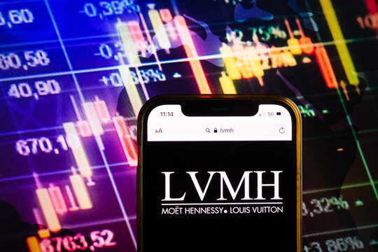 KONSKIE, POLAND - August 07, 2022: Smartphone displaying logo of LVMH Moet Hennessy Louis Vuitton corporation on stock exchange chart background