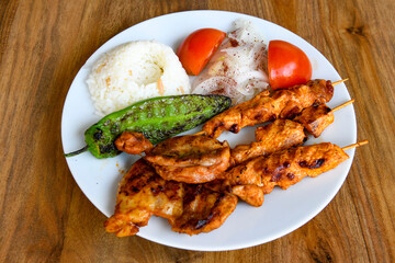 Chicken wings barbeque in a dish with BBQ sauce . Izgara tavuk sis kanat.